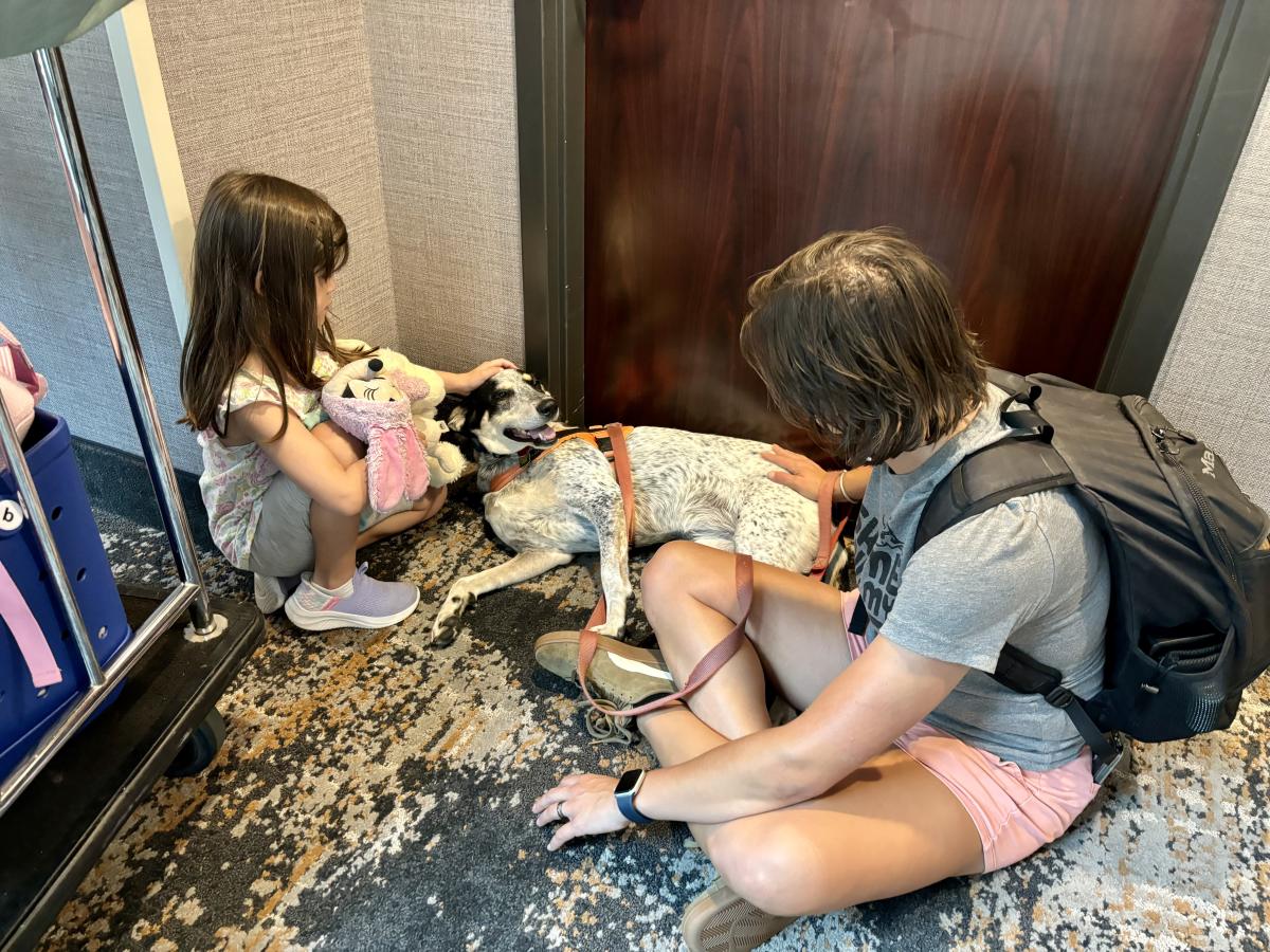 Family relaxing with a dog inside a pet-friendly hotel in downtown Huntsville, Alabama.