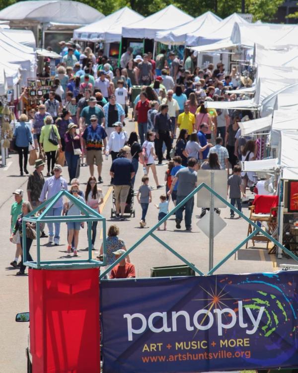 Crowds walk through vendor tents at Panoply Arts Festival in Huntsville, featuring art, music, and local culture.