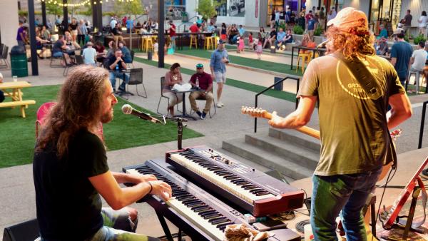Live music performance with keyboard and guitar on an outdoor stage at an entertainment venue in Huntsville
